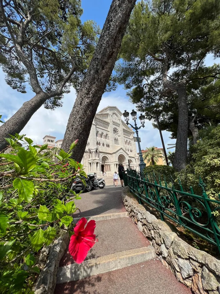 Monaco Cathedral framed by trees and red flowers