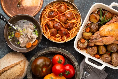 Курица с овощами, паста и хлеб на обеденном столе