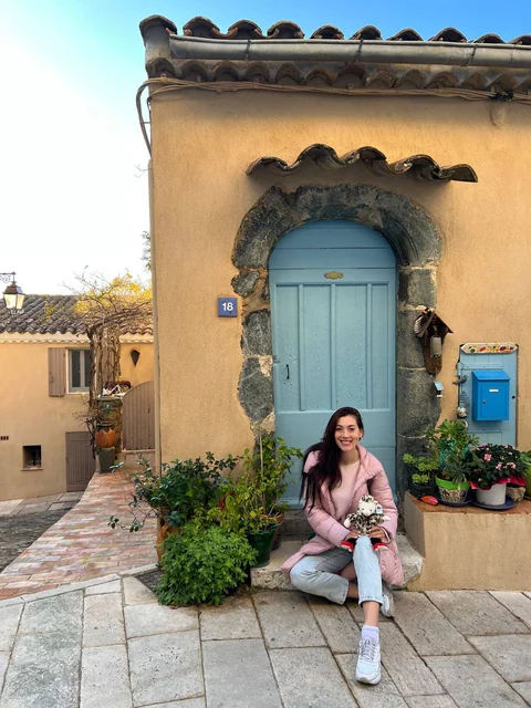 A guest beside the blue door of a Provençal house